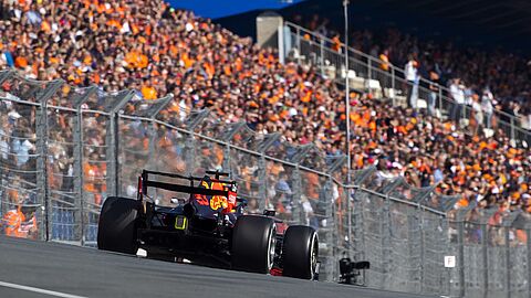 raceauto met oranje gekleed publiek op tribune